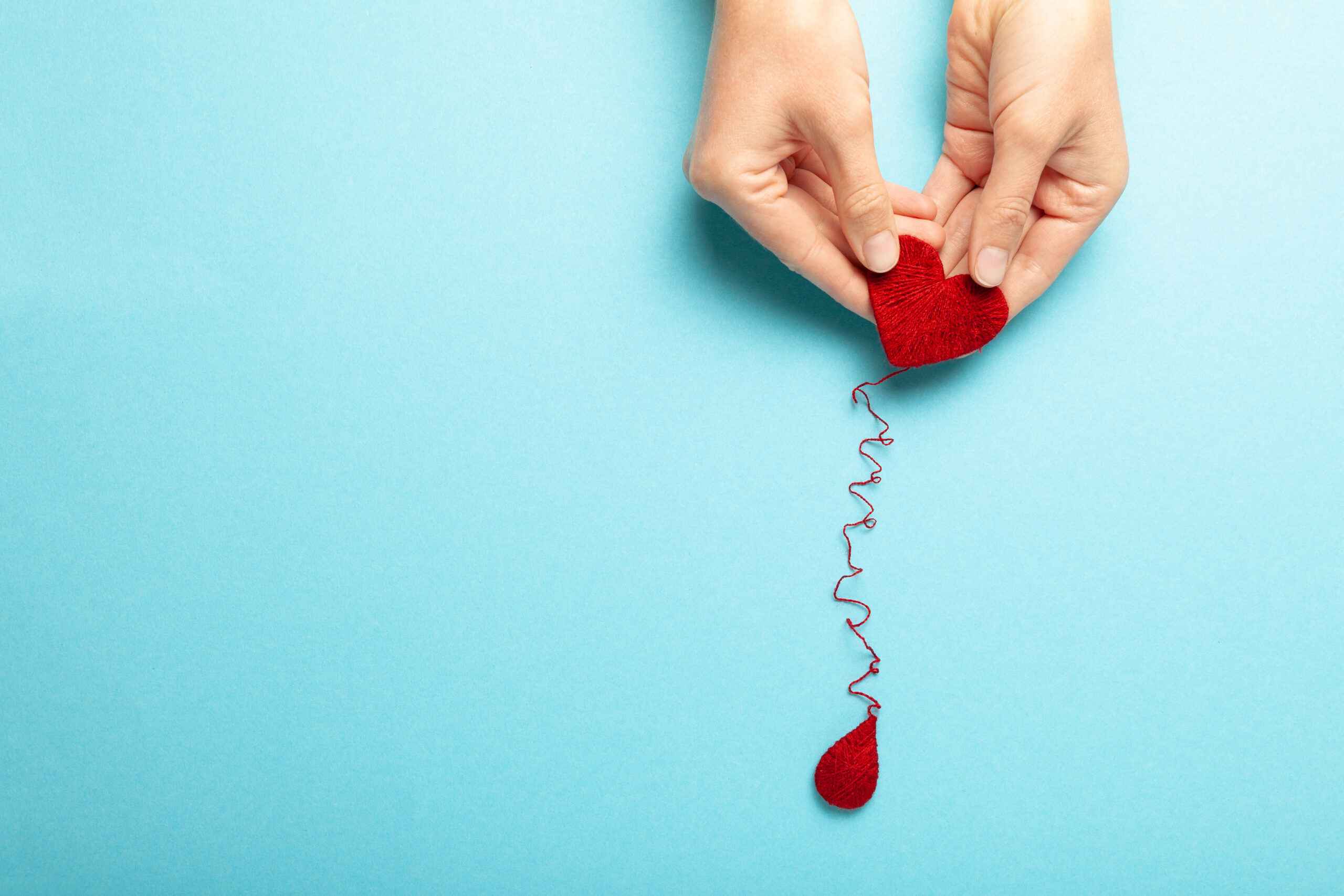 Blood donor. Hands with red heart and drop. Medical donation and blood transfusion.